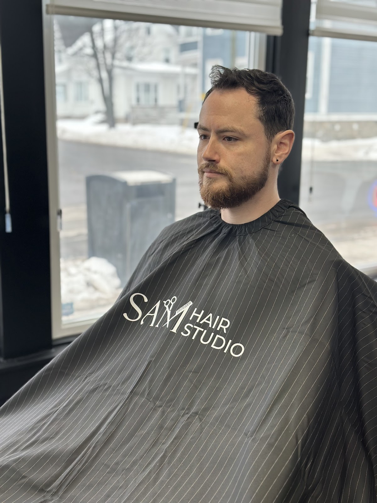 Client caped up in the chair by the studio window