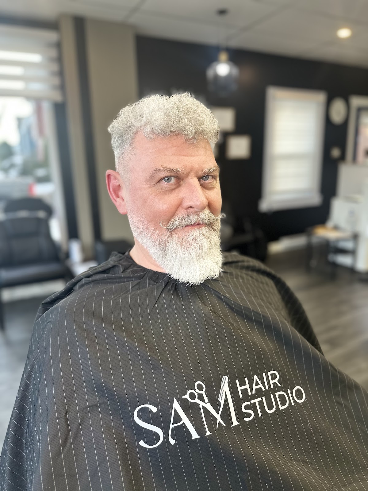 Textured silver curls with a full beard trim